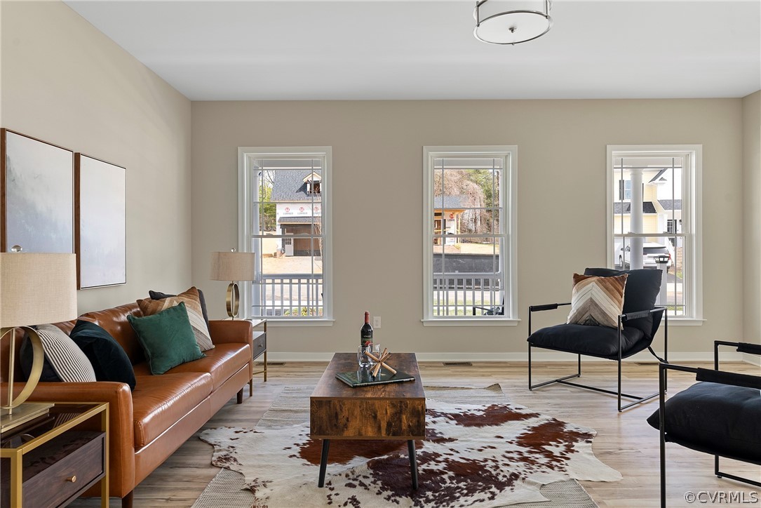 Bright living room with three tall windows and wood-look flooring